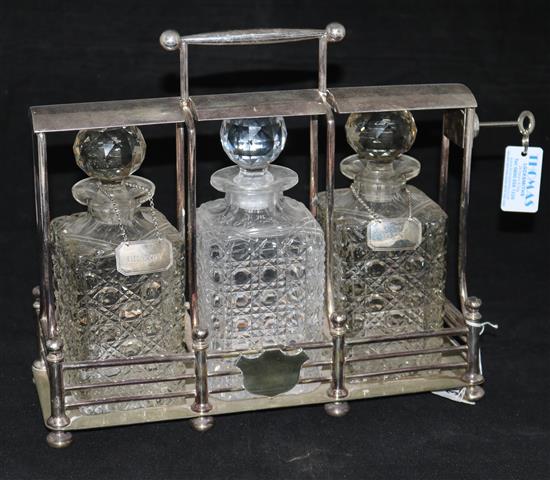 An early 20th century silver plated tantalus by Hobbs & Co, London, with three hobnail cut glass decanters & pr of wine labels, 1.75in.